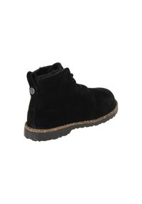 Musta mokkanahkainen nilkkurakenka pyöreällä kärjellä, vähäisellä nauhoituksella ja tekstuurillisella korkkipohjalla. Takana kohollaan oleva brändäysyksityiskohta.