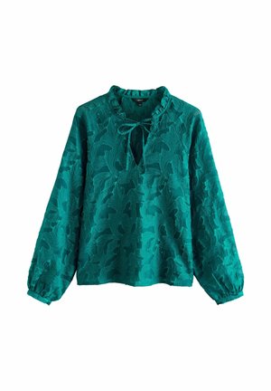 Tengerzöld blúz hosszú ujjakkal, texturált virágmintával, fodros nyakkivágással és megkötővel a mellrésznél az állítható illeszkedés érdekében. Puha, enyhén áttetsző anyag.