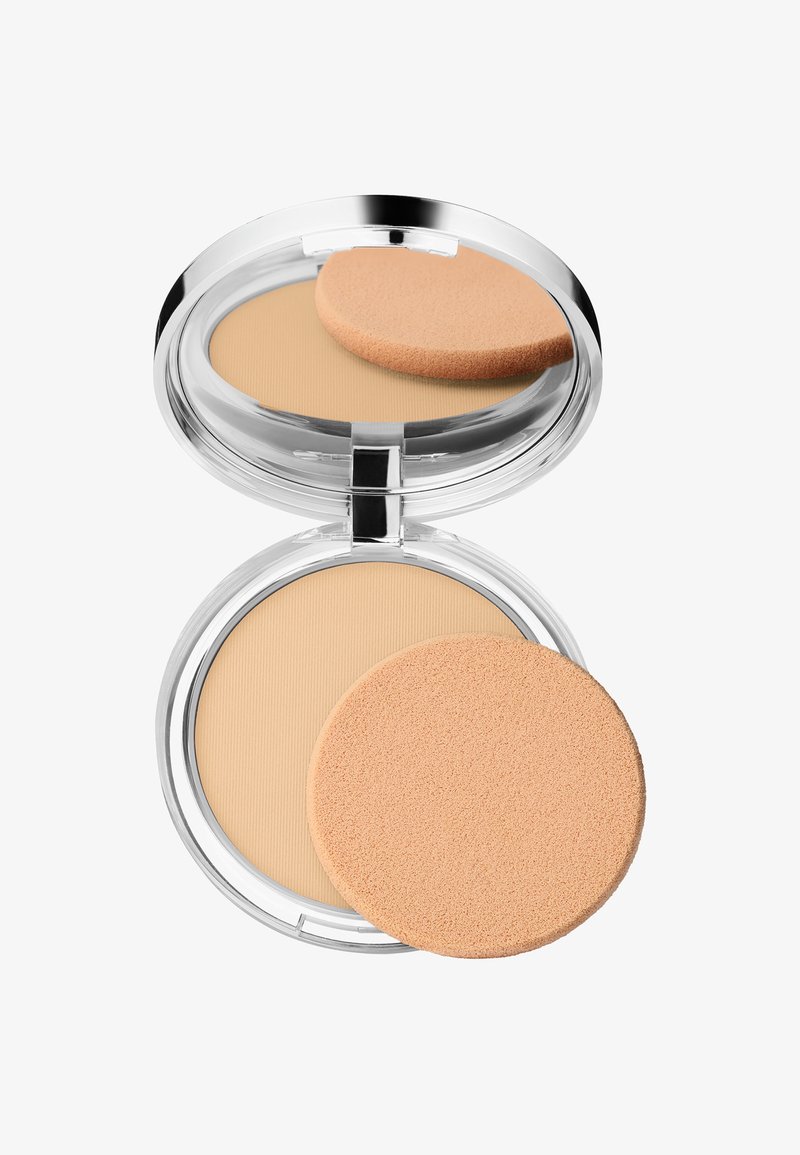 Poudre compacte dans un boîtier en plastique transparent. Présente une poudre lisse et beige ainsi qu'un applicateur rond et doux de couleur pêche clair.