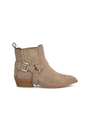 Beige Wildleder-Stiefeletten mit spitzer Zehenform, dekorativem Schnallenriemen, vertikalen Nähten und einem gestapelten Absatz. Glatte Textur mit silbernen Hardware-Details.