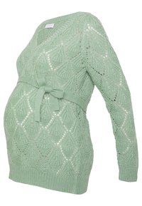 Pull de maternité vert clair avec encolure en V, motif en tricot diamant complexe et ceinture nouée à la taille. Manches longues et texture douce.