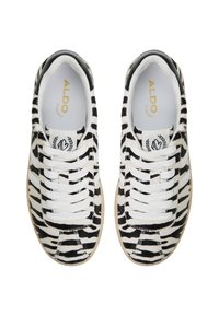 White and black zebra-striped sneakers with lace-up closure, rubber outsole, and soft inner lining. Features logo tag on side.