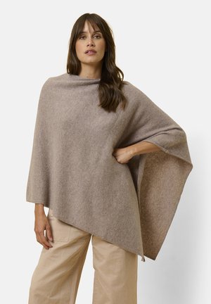 Poncho in un morbido misto lana beige; forma ampia e drappeggiata con cuciture minime; presenta una texture sottile e un bordo arrotolato al colletto.