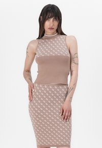 Top en tricot marron avec un motif blanc, associé à une jupe crayon assortie. Le tissu est côtelé et présente un col haut.