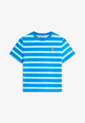 Modré a biele horizontálne pruhované tričko s krátkym rukávom so žltým logom "TH" na hrudi a malým detailom vlajky na rukáve.