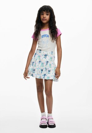 Cămașă cu mâneci scurte și guler roz, având textul „STITCH” și o imagine, asortată cu o fustă evazată albă cu imprimeuri colorate cu personaje.