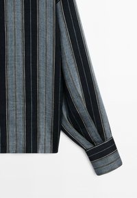 Long-sleeve shirt sleeve with vertical black and gray stripes and a buttoned cuff on white background.