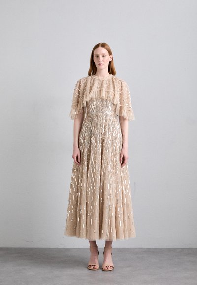 Robe beige avec des manches à volants superposés, ornée de paillettes argentées. Jupe longue et fluide avec des motifs verticaux.