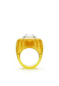 Żółty pierścionek z żywicy z dużym, przezroczystym kamieniem przypominającym diament na górze, charakteryzujący się gładkim, błyszczącym wykończeniem i minimalistycznym wzornictwem.