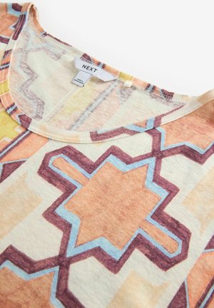 T-shirt z krótkim rękawem wykonany z lekkiego materiału, z geometrycznym wzorem w kolorach pomarańczowym, żółtym i niebieskim na kremowym tle.