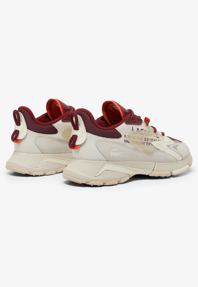 Sneakers Lacoste con una combinazione di colori beige e bordeaux; realizzati in materiali in rete e sintetici; caviglia imbottita; linguette per facilitare l'uso; suola con motivo.