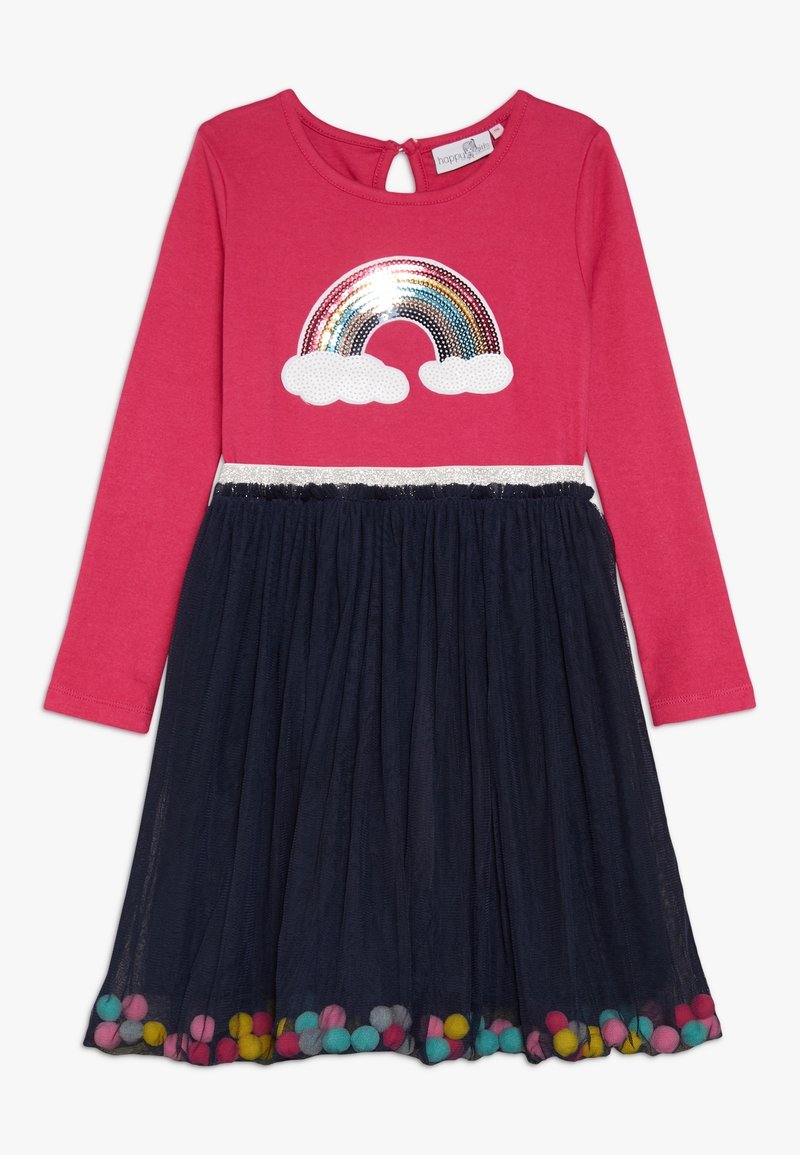 Pitkähihaista mekko, jossa on vaaleanpunainen yläosa sateenkaaren ja pilven kuvioinnilla. Laivastonsininen organzakangashelma, jossa on värikkäitä pom-pom-viimeistelyjä helman reunassa.