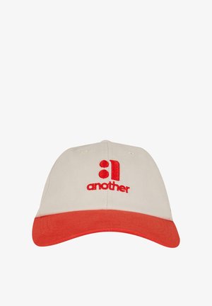 Cap made of beige cotton with a red brim. Features red embroidered text "another" and accents in the same color.