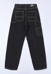 Mustat denim-housut rentoa mallia, joissa on useita taskuja, näkyvät ompeleet ja suora lahje.