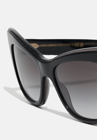 Black oversized sunglasses with a butterfly shape, featuring dark gradient lenses and a smooth matte finish on the frame.