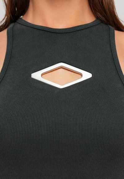 Close-up of a woman wearing a black ribbed sleeveless top with a diamond-shaped cutout at the chest.