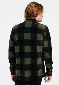 Groen en zwart geruit flanellen overhemd met een kraag, knoopmanchetten en een ontspannen pasvorm. Zachte textuur met een afgeronde zoom en een opvallend patroon.