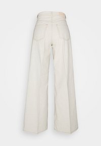 High-waisted wide-leg jeans in light beige cotton. Features two back pockets and visible stitching. Smooth texture with a minimal design.