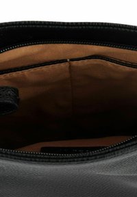 Schwarze Lederhandtasche Innenraum, mit glattem beigen Futter, Kontrastnähten und einem Reißverschluss, mit einem einzigen Fach für die Aufbewahrung.