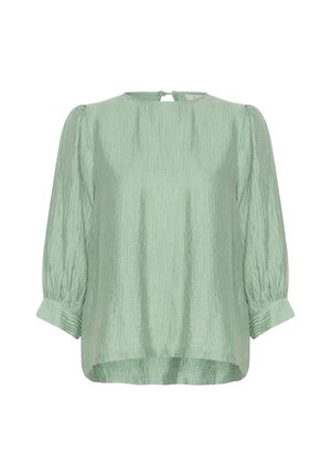 Lichtgroene blouse met een textuurafwerking, ronde halslijn en driekwart pofmouwen. De achterkant heeft een sleutelgatopening met een knoop.