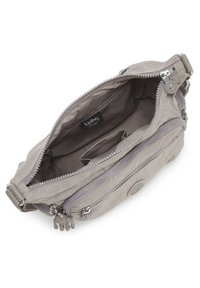 Borsa grigia con chiusura a zip, multiple tasche, texture in tessuto e un emblema con logo. L'interno è foderato con un materiale morbido, con scomparti.