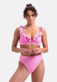 Růžový bikiny set s texturovanou tkaninou, hlubokým V-výstřihem s volánkovým lemem a vysokým pasem. Hladký povrch, žádné viditelné kovové prvky.