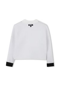 Maglione cropped bianco a maniche lunghe con polsi neri, colletto a coste e etichetta del marchio DKNY sulla parte superiore della schiena.