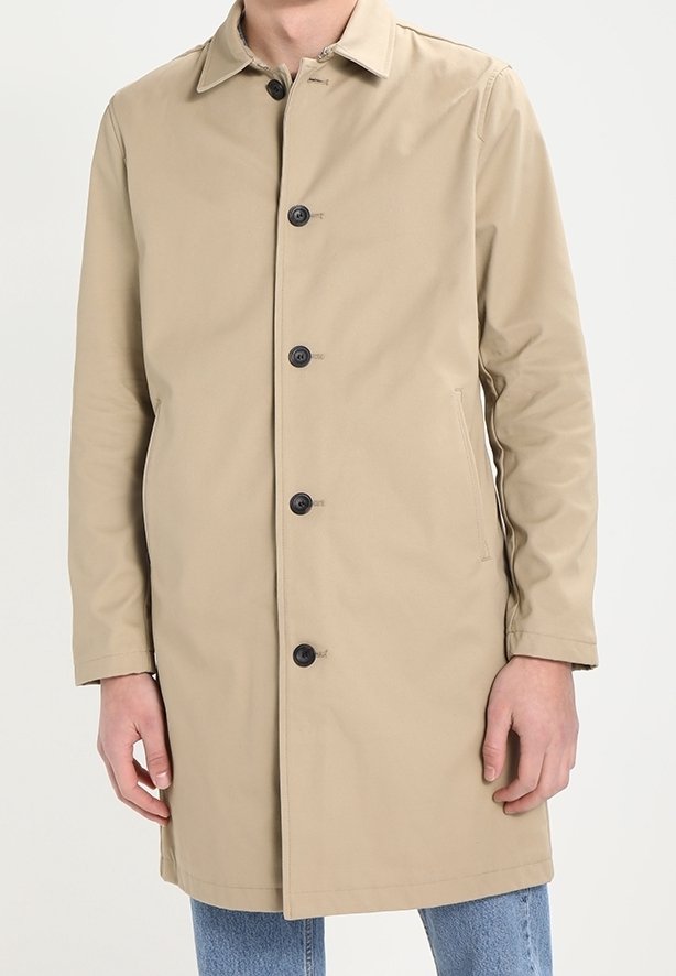 Trench coat beige con colletto e sei bottoni neri, dotato di tasche laterali e una linea dritta, realizzato in un tessuto leggero e liscio.