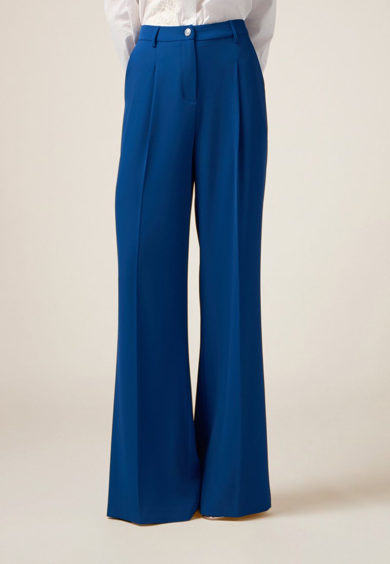 Pantaloni a gamba larga blu realizzati in tessuto liscio, con pieghe frontali e chiusura a bottone in vita.