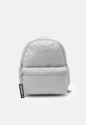 Lichtgrijze Nike-rugzak met voorvak met ritssluiting en zwarte ritsmet trekker met de tekst "JUST DO IT.", weergegeven op een witte achtergrond.
