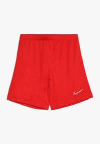 Pantalones cortos deportivos rojos con cintura elástica y logo blanco de Nike en la parte inferior de la pierna derecha, exhibidos sobre un fondo blanco.