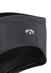 Svart badkläder med slät textur, elastisk midja och kontrasterande vit "Billabong"-logotyp. Har ren sömnad och en minimalistisk design.