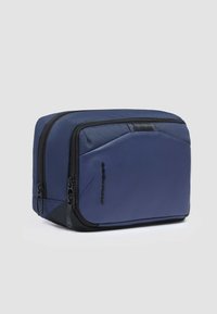 Beauty case blu navy con tessuto a trama, dettagli lisci, due scomparti con zip e design elegante; presenta un logo ben visibile.