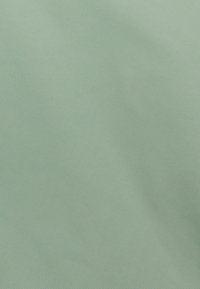 Tessuto morbido di un verde menta con righe diagonali e leggere variazioni di luce e ombra.