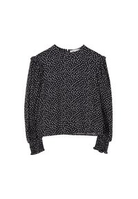 Blouse noire à manches longues avec pois blancs irréguliers, poignets froncés, épaules bouffantes et fermeture boutonnée dans le dos au niveau du col.