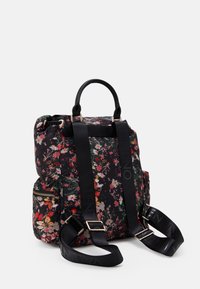 Svart blommig ryggsäck med vadderad yta, dubbla handtag upptill, justerbara axelremmar och en sidoficka med dragkedja. Har en flerfärgad blomdesign.