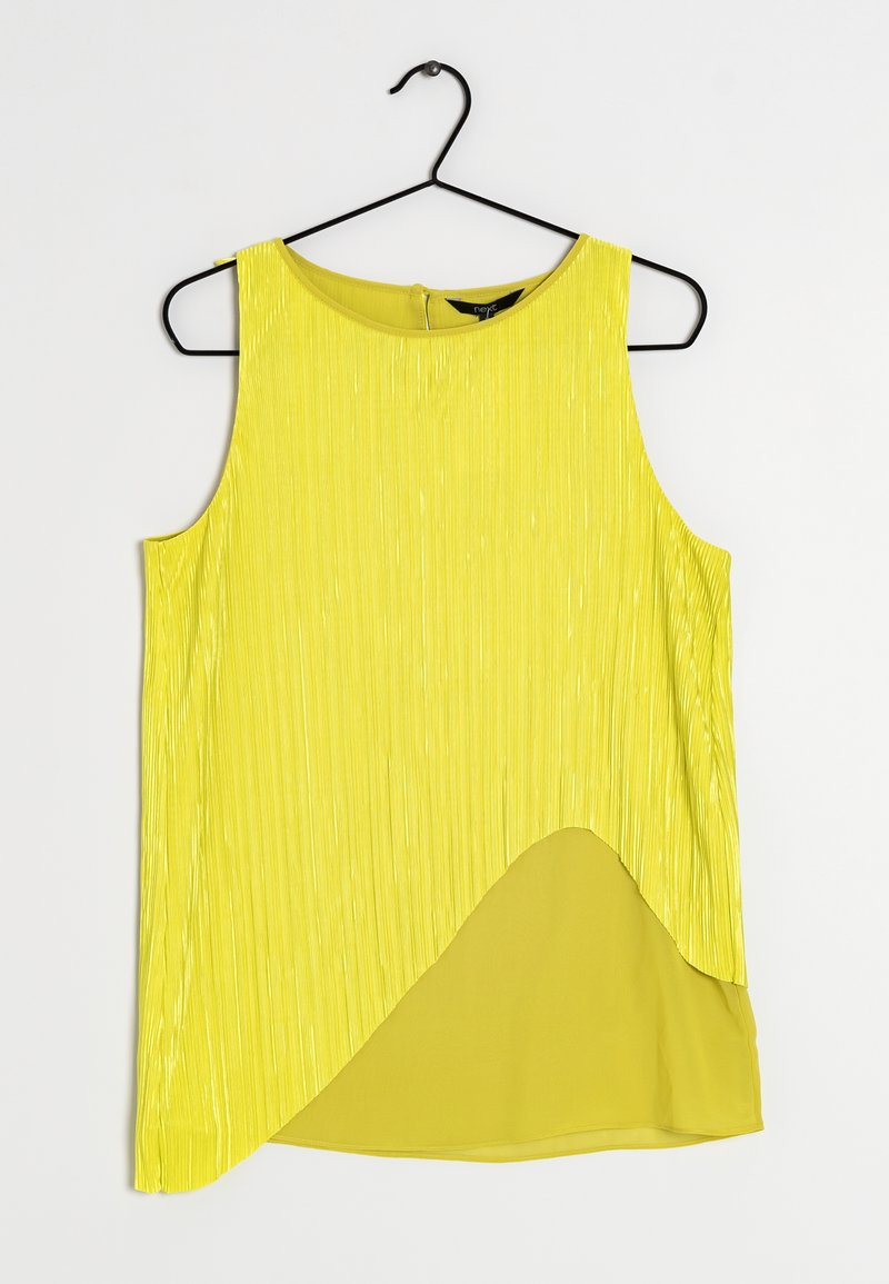 Hihaton keltainen paita, jossa on pystysuora poimutustekstuuri, kaareva helma ja kontrastoiva tasainen keltainen kangas. Roikkuu mustassa koukussa.