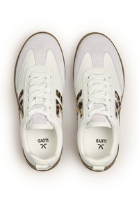 Un paio di sneakers bianche con punte in suede, strisce laterali con stampa leopardata, lacci bianchi e suole in gomma marrone, viste dall'alto.