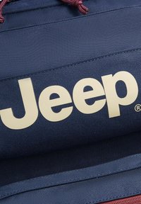 Borsa blu navy con un grande logo bianco "Jeep". Tessuto texturizzato, cordino regolabile color bordeaux, con cuciture rinforzate.