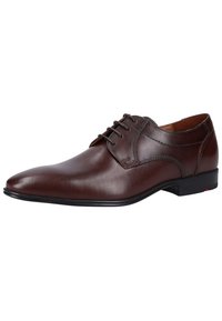 Braune Lederschuhe mit spitzem Zehenbereich, Schnürdesign und feinen Steppnähten, ausgestattet mit einer dünnen schwarzen Sohle und einem leichten Absatz.