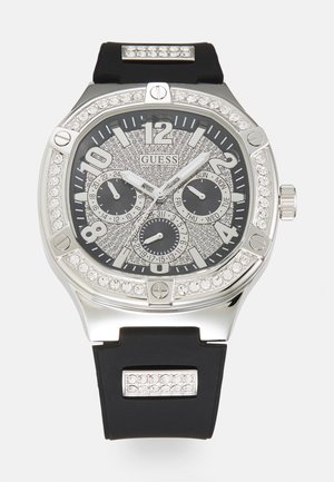 Schwarze Silikonarmbanduhr mit einem Gehäuse aus silbernem Edelstahl, funkensprühendem schwarzen Zifferblatt, drei Ziffernblättern und Kristallverzierungen am Gehäuse.