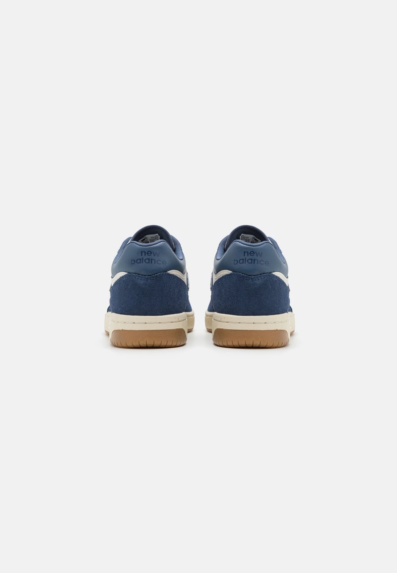 Navyblaue Wildleder-Sneaker mit einer strukturierten Oberseite und cremefarbenen Akzenten. Verfügt über eine markenbezogene Ferse und eine kontrastierende Gummi-Außensohle.
