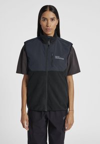 Svart och mörkgrå väst med dragkedja fram, hög krage och logodetalj på bröstet. Tillverkad av fleece och mjukt material.