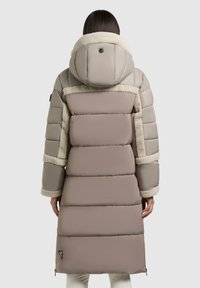 Padded long coat in beżowym i taupe, z kapturem z futrzanym wykończeniem, akcentami bocznych kieszeni oraz naszywką z logo w pobliżu dolnej krawędzi.