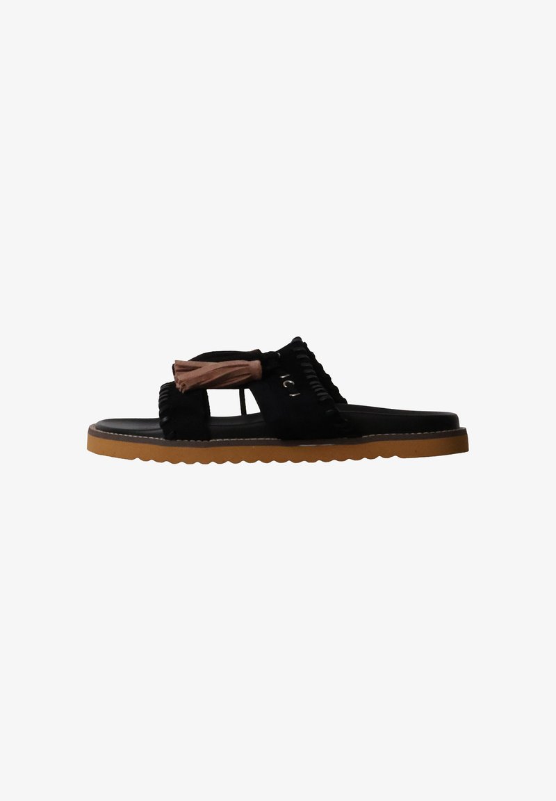 Sandale noire slip-on avec décoration de pompon marron et semelle en caoutchouc beige avec détails de couture sur fond blanc.