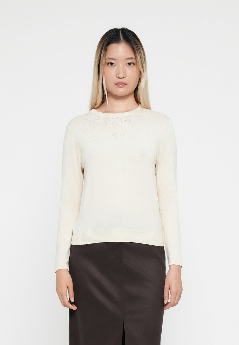 Cream-colored long-sleeve sweater with a ribbed hem and subtle bead accents along the neckline, made of lightweight knit material.