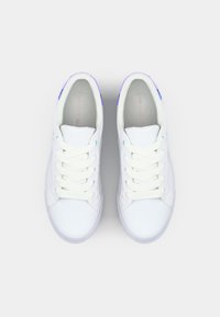 White sneakers with a smooth leather upper, round toe, flat laces, purple and blue accents, and a cushioned insole.