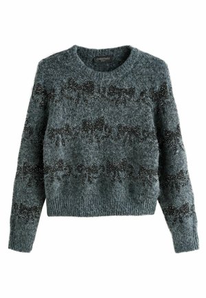 Grå stickad tröja med ett mjukt, strukturerat tyg som har ett mönster av svarta rosetter och spridda paljetter. Rund halsringning och långa ärmar.