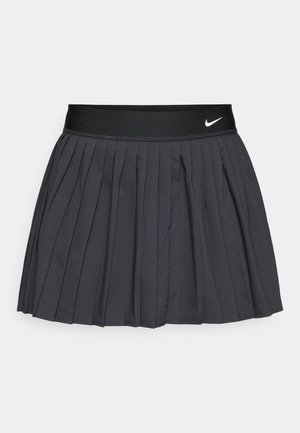 Crna plisirana suknja s teksturiranim dizajnom i elastičnim pojasom s bijelim Nike logotipom. Glatki materijal s ravnomjerno raspoređenim naborima oko ruba.