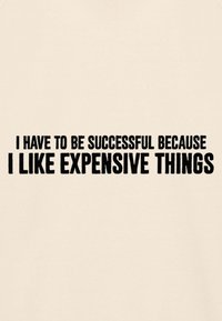 Testo in grassetto nero su sfondo beige recita: "Devo avere successo perché mi piacciono le cose costose."